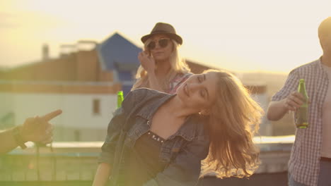 Dancing-girl-rooftop-party-slow-motion-group-of-multiracial-friends-hanging-out-young-asian-woman-dancing-enjoying-roof-top-event-at-sunset-drinking-alcohol-having-fun-on-weekend-celebration